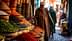 A man in traditional attire walking past colorful spice displays in a market setting. - Olive Oil Times