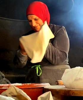 A woman wearing a red headscarf is preparing dough in a kitchen setting. - Olive Oil Times
