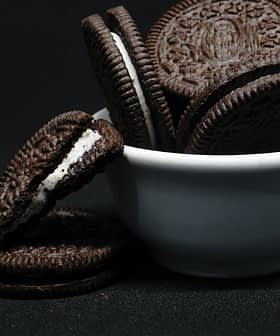 A white bowl filled with Oreo cookies, some cookies stacked and one cookie with cream filling visible. - Olive Oil Times