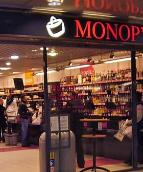Entrance of a Monop' grocery store featuring shelves stocked with various products. - Olive Oil Times