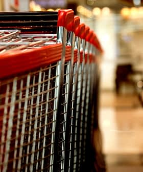 A row of shopping carts with red handles lined up in a retail environment. - Olive Oil Times