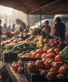 Various fruits and vegetables displayed on tables at a market stall during the day. - Olive Oil Times