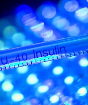 Close-up of a U-40 insulin syringe with a red cap against a blue and green background. - Olive Oil Times