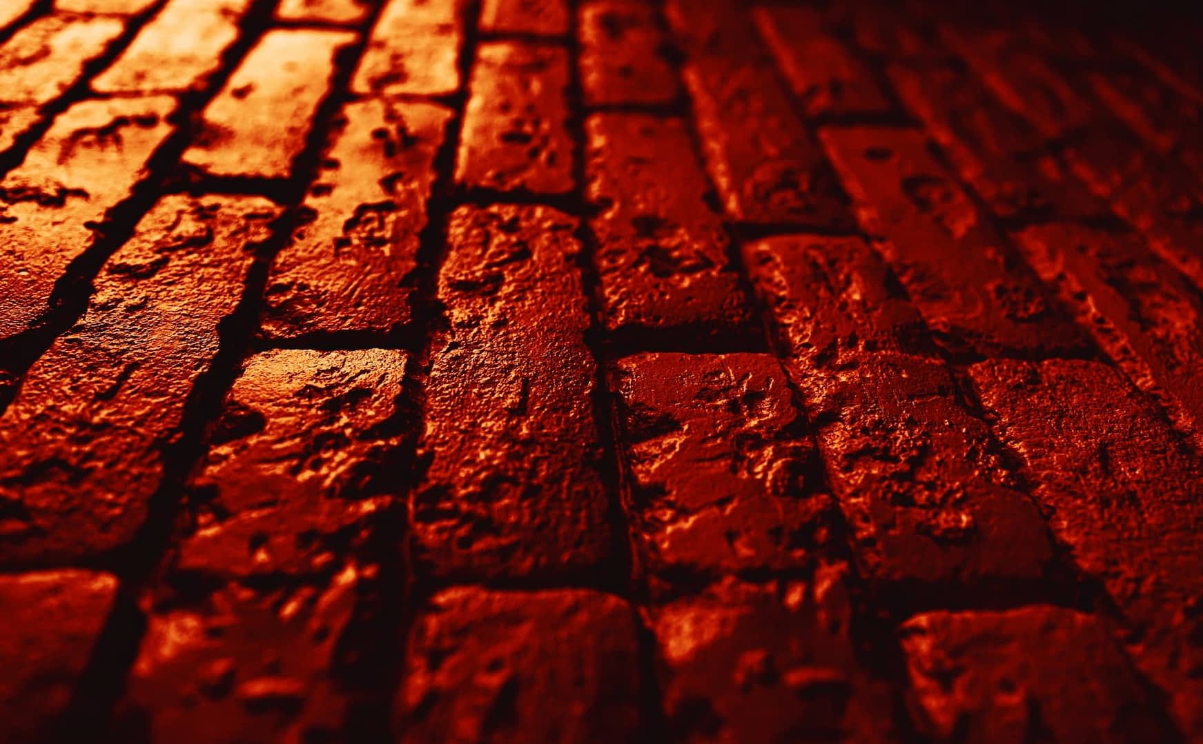 Close-up view of a textured red brick surface with visible imperfections and patterns. - Olive Oil Times