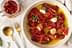 Bowl of marinated sun-dried tomatoes with garlic and herbs in olive oil. - Olive Oil Times