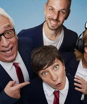 Four individuals posing together, two wearing glasses and one with headphones, all in formal attire with blue background. - Olive Oil Times