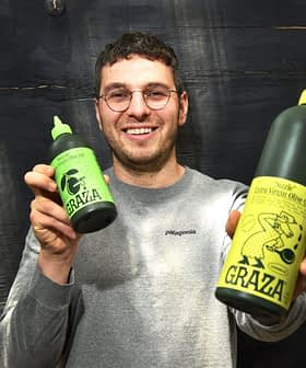 Person holding two bottles of Grazia extra virgin olive oil, one large and one small, both with green labels. - Olive Oil Times