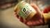 Hand holding a jar labeled with an eco score rating and a green logo. - Olive Oil Times