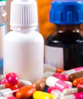 Various pharmaceutical bottles and colorful capsules arranged on a surface. - Olive Oil Times