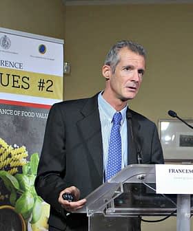 Francesco Visioli speaking at the International Conference on Food Values with a presentation backdrop. - Olive Oil Times
