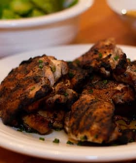 grilled chicken thighs on a plate seasoned with lemon and olive oil