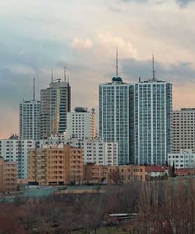 Cityscape of Tehran featuring the Milad Tower and various buildings under a cloudy sky. - Olive Oil Times